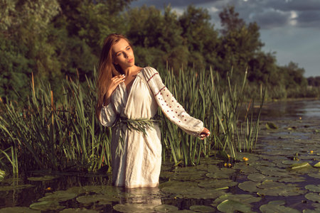 Girl in an embroidered dress on the lakeの写真素材