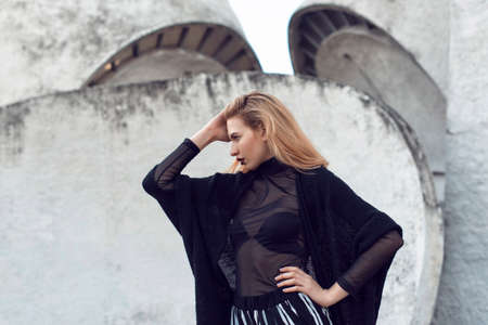 Blonde posing near the wall of the building