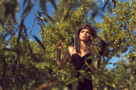 Girl on the sand wearing an Indian headdress