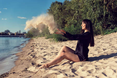 Girl on the sand near the riverの写真素材