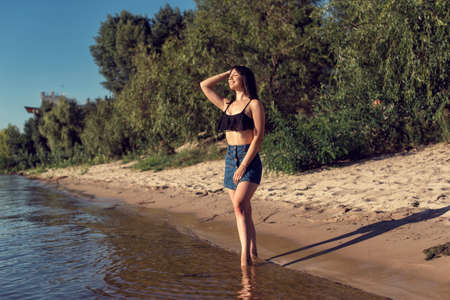 Girl on the sand near the riverの写真素材