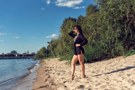 Girl on the sand near the riverの写真素材