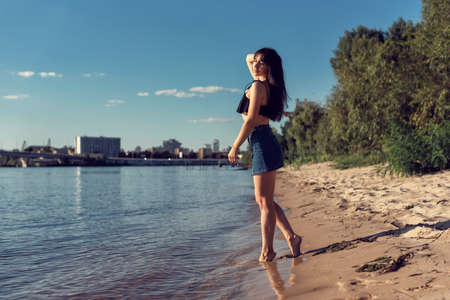 Girl on the sand near the riverの写真素材