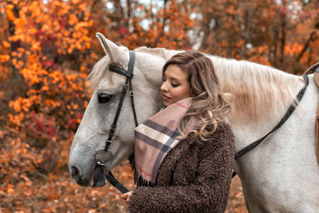 Young woman in the park with a horseの写真素材