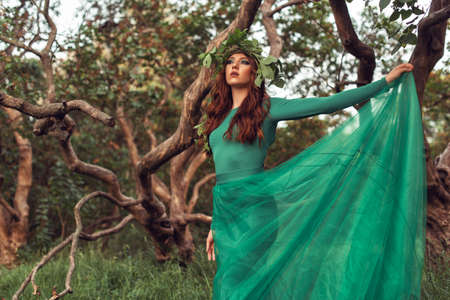 Young woman in green dress in the park