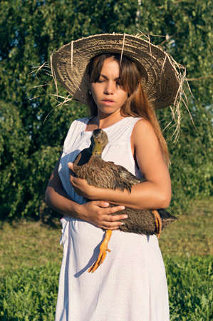 Girl in a hat with a gooseの写真素材
