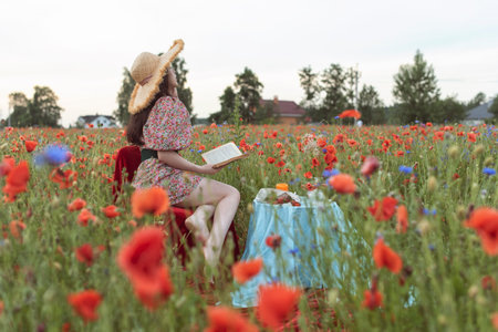 A young girl in a flowering poppy fieldの写真素材