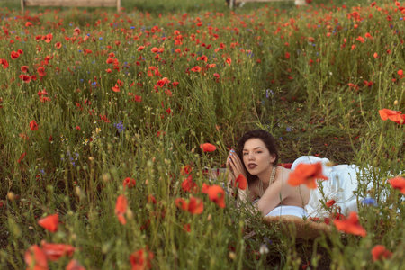 A young girl in a flowering poppy fieldの写真素材