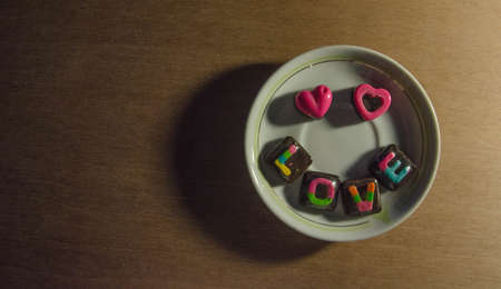 A Pink-Heart lovely face Chocolate on top of a plate, on the wood.の写真素材