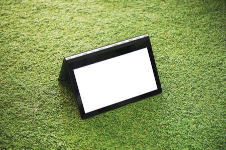 Laptop with blank white screen on the green grassの写真素材