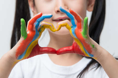 child hands painted make a heart shapeの写真素材