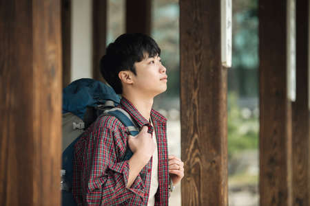 A young man doing a backpacking trip in a Korean traditional house.の写真素材