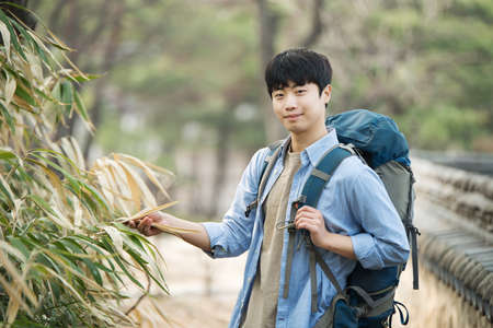 A young man doing a backpacking trip in a Korean traditional house.の写真素材