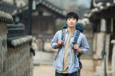 A young man doing a backpacking trip in a Korean traditional house.の写真素材