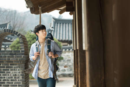 A young man doing a backpacking trip in a Korean traditional house.の写真素材