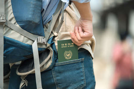 Travelers take their Korean passports out of their jeans back pockets.の写真素材