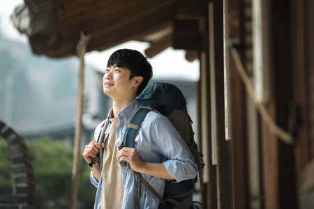 A young man doing a backpacking trip in a Korean traditional house.の写真素材