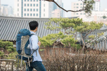 A young man doing a backpacking trip in a Korean traditional house.の写真素材