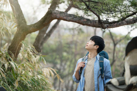 A young man doing a backpacking trip in a Korean traditional house.の写真素材