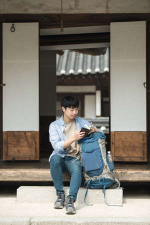 A young man traveling to Korea. taking a rest and watching his passport.