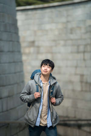 A young man doing a backpacking trip in a Korean traditional house.