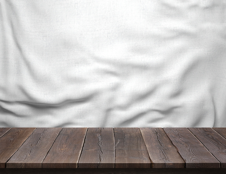 Wood table with white cotton fabric backgroundの写真素材