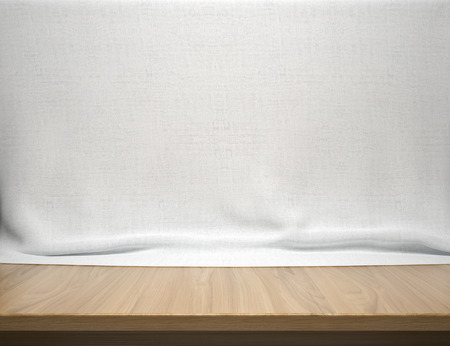 Wood table with white cotton fabric backgroundの写真素材