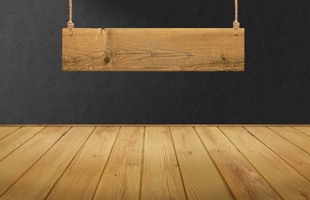 Wood table with hanging wooden sign on black concrete wallの写真素材