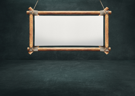 Wooden sign board hanging on dark background wallの写真素材