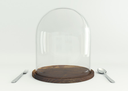 Glass dome on wooden tray with spoon and fork on white table backgroundの写真素材