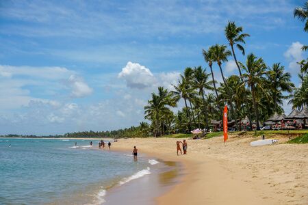 Tourists enjoying tropical white sand beach and turquoise sea water. Praia do Forte, Bahia, Brazil. Travel tropical luxury conceptのeditorial素材