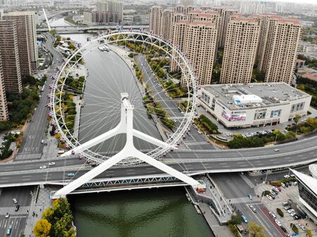 Tianjin, China, October 28th, 2019: Aerial view cityscape of Tianjin ferris wheel. Famous Tianjin Eye ferris wheel above the Yongle Bridge and the Haihe river.のeditorial素材