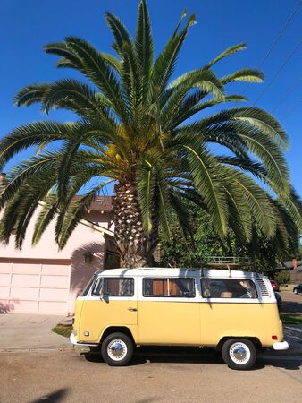 Classic beige and white vintage Volkswagen T1 camper van parked in front of pink house. San Diego, California, USA. July 13th, 2019のeditorial素材