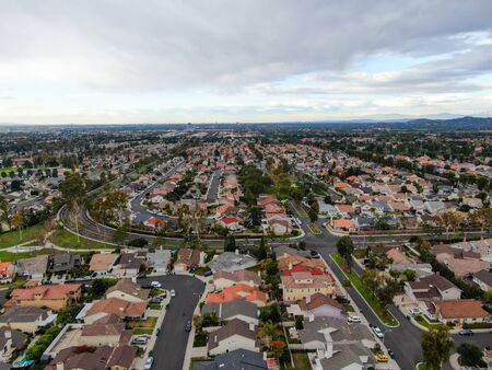 Aerial view of urban sprawl. Suburban packed homes neighborhood with road.during clouded day. Vast...