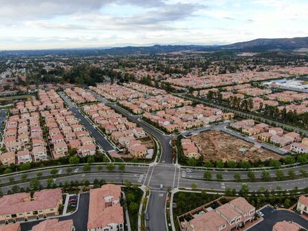 Aerial view of urban sprawl. Suburban packed homes neighborhood with road.during clouded day. Vast subdivision in Irvine, California, USAの写真素材