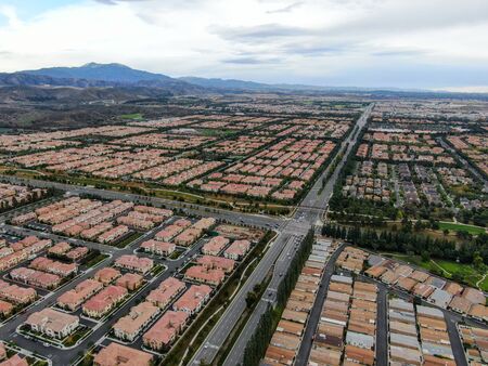 Aerial view of urban sprawl. Suburban packed homes neighborhood with road.during clouded day. Vast subdivision in Irvine, California, USAの写真素材