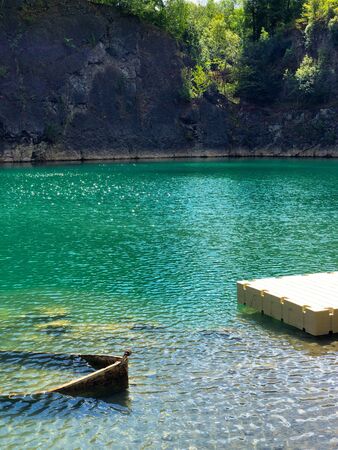 Abandoned boat in flooded quarry with blue crystal water. Diver site with fresh blue and clean water...