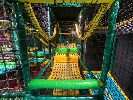 Modern children playground indoor. Inside the colorful kids jungle for playing and development of motor skills. Kids playground for gym with slide and mazeの写真素材