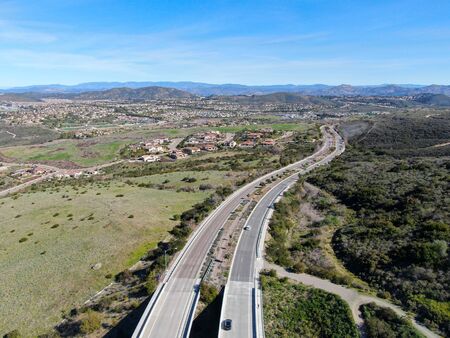 Curving road and downhill with houses in suburb of San Diego, California, USA