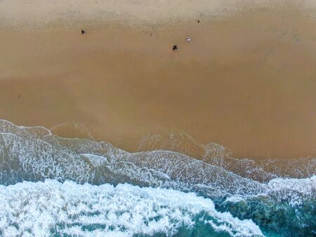 Aerial top view of the ocean colorful waves washing on the coast of the Pacific ocean. California....