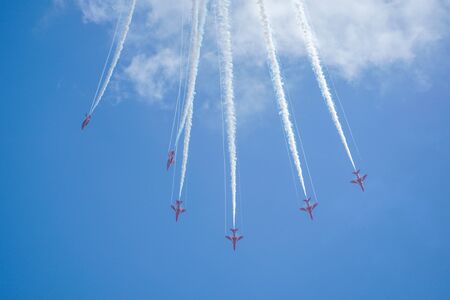 Aerobatic plane with white smoke in the blue sky, California, USA.