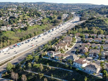 Aerial view of highway with traffic surrounded by houses in Diamond Bar City. Intersection city...