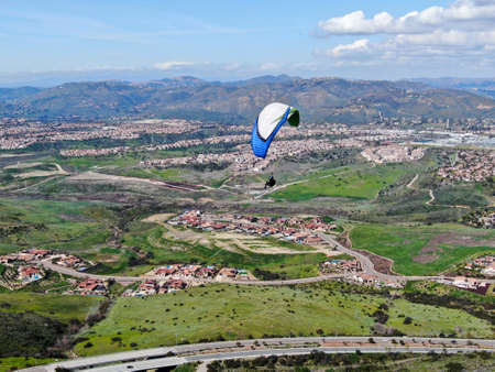 Para-glider over the top of the mountain during summer sunny day. Para-glider on the para-plane, strops -soaring flight moment flying over Black Mountain in San Diego, California. USA. February 22nd, 2020のeditorial素材