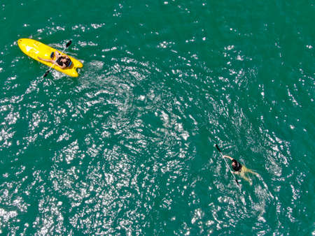 Aerial view view of strong young active men kayaking on the clear blue turquoise water of the ocean. Active vacation. Praia do Forte, Brazil. February 21th, 2019のeditorial素材