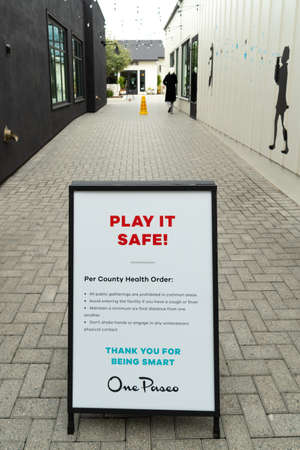Empty outdoor shopping mall with informative signage during COVID-19 pandemic. Coronavirus virus...