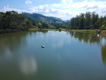 Aerial view of couple on the pedal boat on the lake in Brazil. Drone view of romantic scene of couple on pedal boat with mountain and forest on the back, Holiday fun on a pedalo. February, 22nd, 2020のeditorial素材