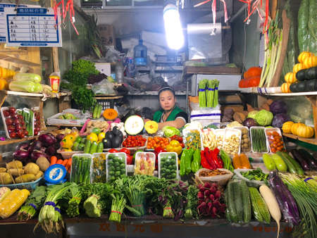 Market with various colorful vegetables and seller, Beijing, China, June 16, 2019のeditorial素材