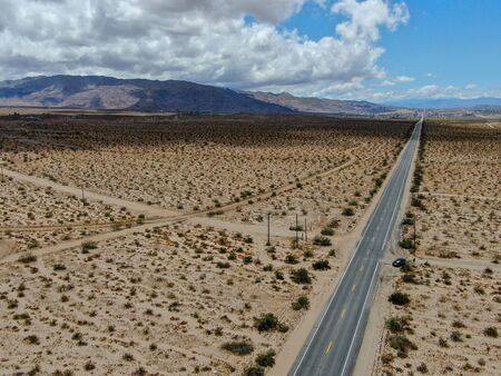 Aerial view of endless desert straight dusty asphalt road in Joshua Tree Park. USA. Long straight...