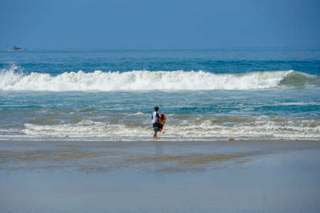 Young kid at the beach enjoying the waves and beautiful summer day at Huntington Beach, California. USA July 13th, 2020のeditorial素材