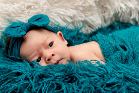 Newborn baby 2 weeks old in blue fluffy blanket. Portrait of pretty newborn baby.の写真素材